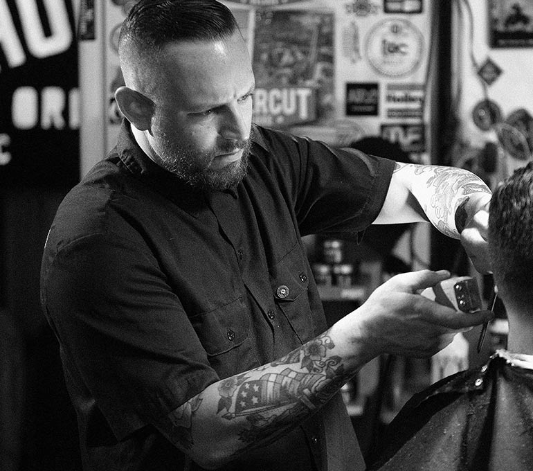 Barber Dane Hesse using a clipper to cut a man's hair