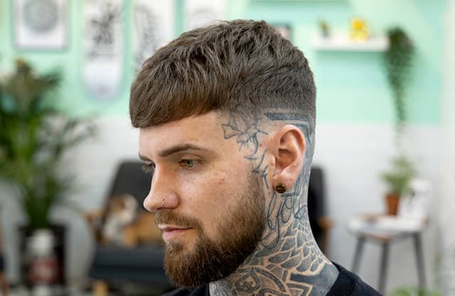 Man with cut, styled hair and tattoos