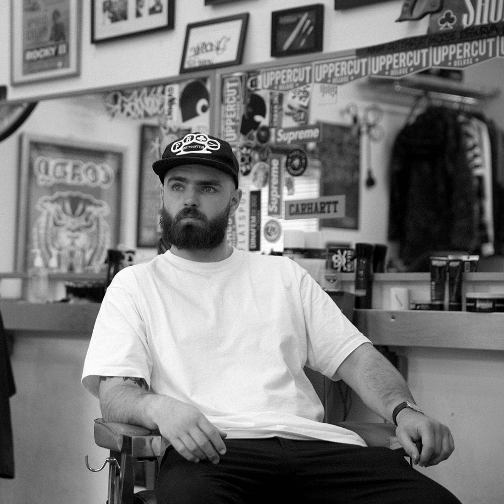 Barber George Coady sitting in barber chair