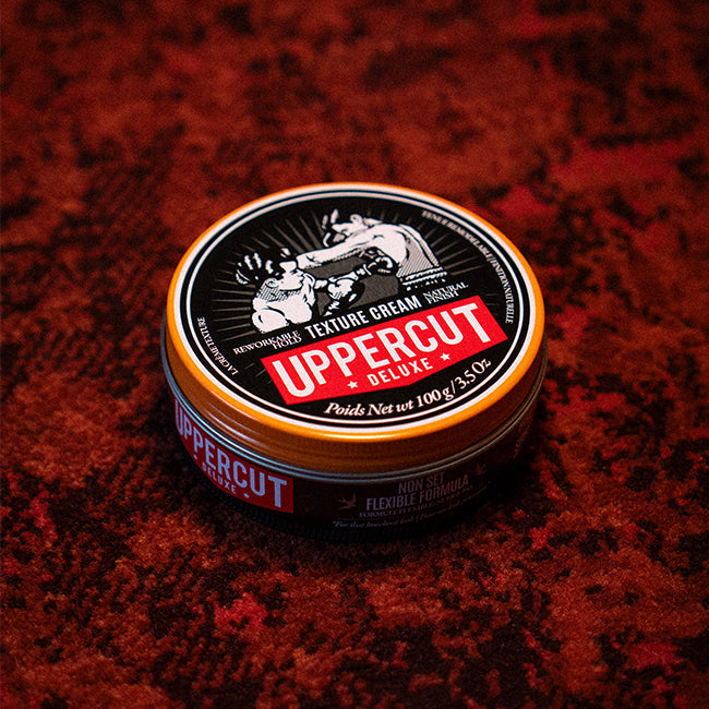 Uppercut Deluxe Texture Cream sitting on a rug