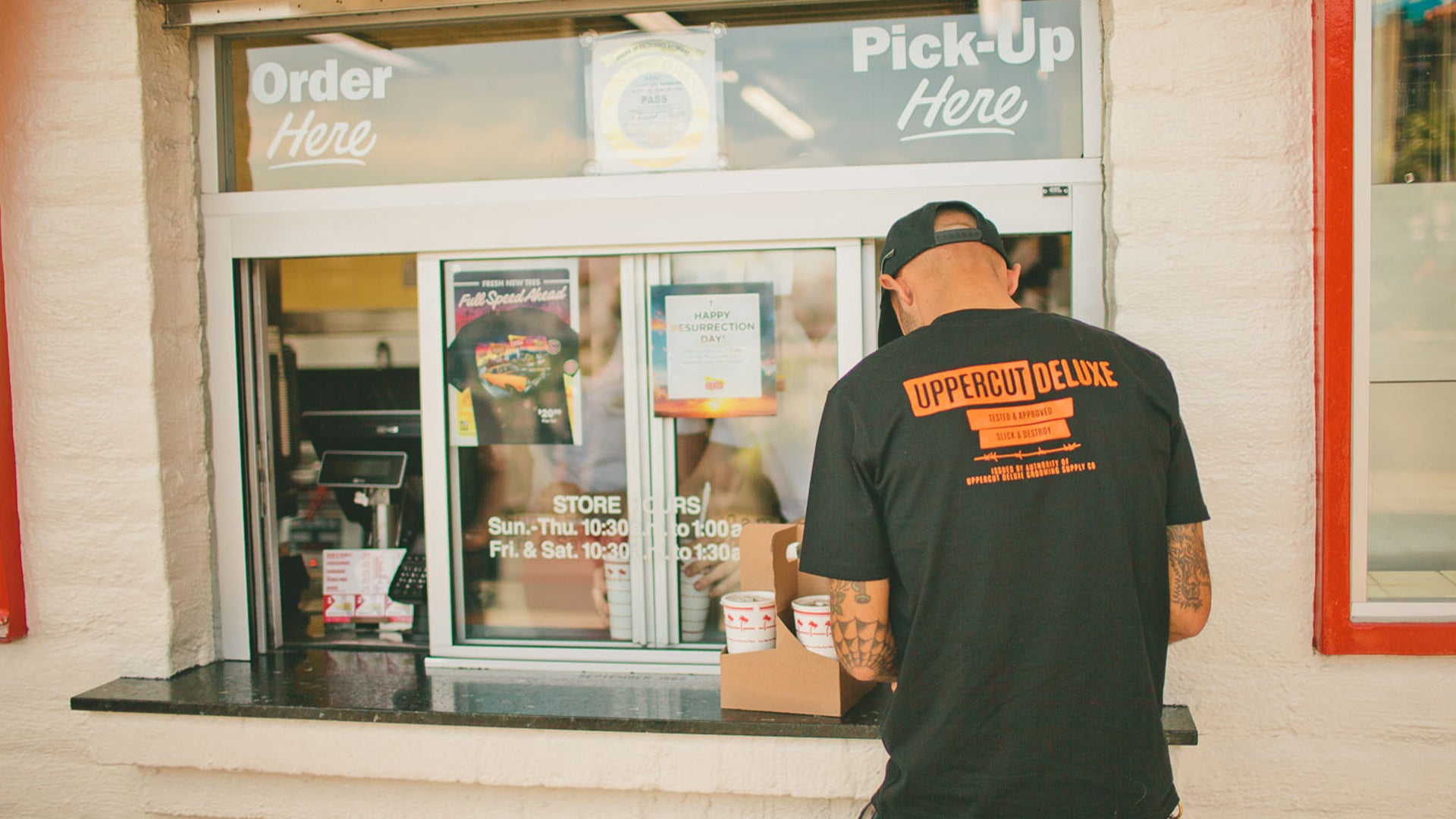Man ordering food wearing uppercut deluxe headliner shirt and hat