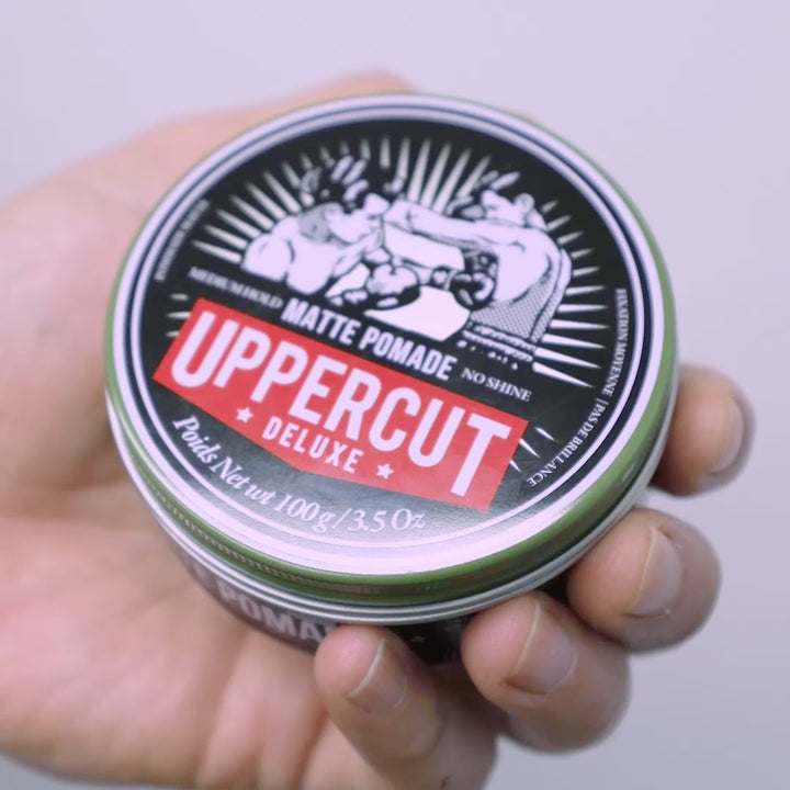 Uppercut Deluxe Matte Pomade tin being opened, scooped and spread through hands.